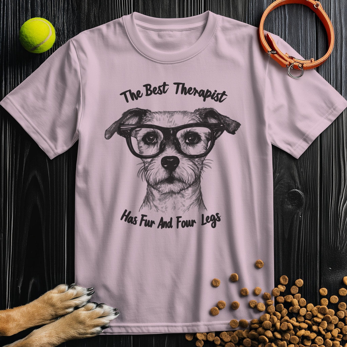 Light pink T-shirt featuring dog illustration and 'The Best Therapist Has Fur And Four Legs' text. Soft cotton, ideal for women’s casual wear.