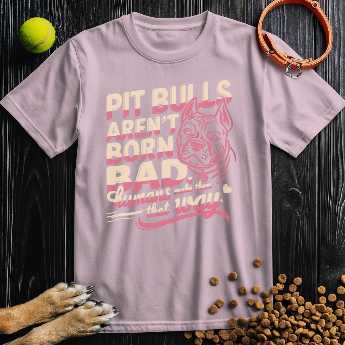 Light pink Not Born Bad Pitbull T-Shirt featuring bold advocacy message and pitbull art, made from sustainable cotton.