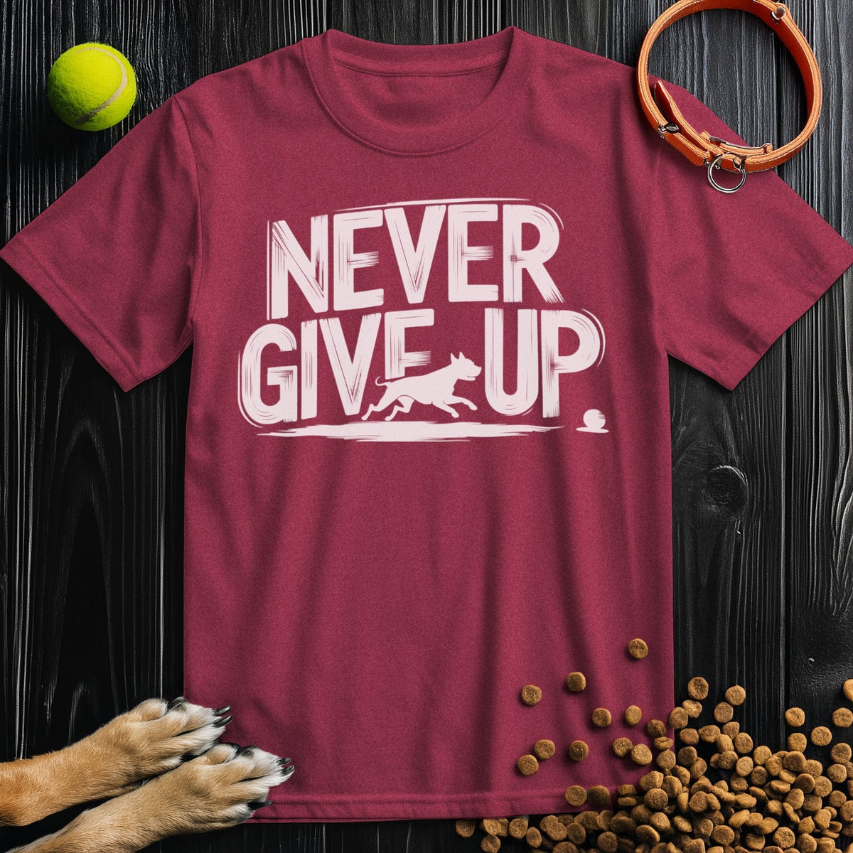 Never Give Up Tee in maroon featuring dog chasing ball graphic. Regular fit cotton t-shirt for men and women, great for casual styling.