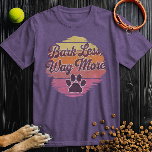 Purple Bark Less, Wag More T-Shirt for dog lovers featuring a sunset design and paw print. Made from 100% cotton, unisex fit.