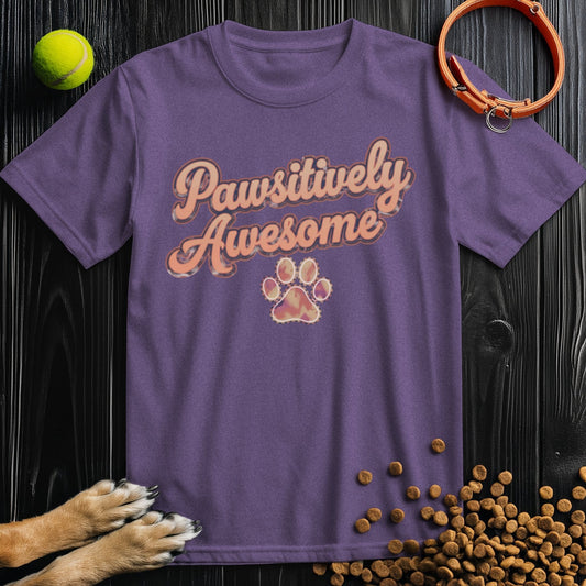 Purple unisex dog theme shirt with 'Pawsitively Awesome' text and paw print, made from 100% cotton. Ideal for dog lovers and casual wear.