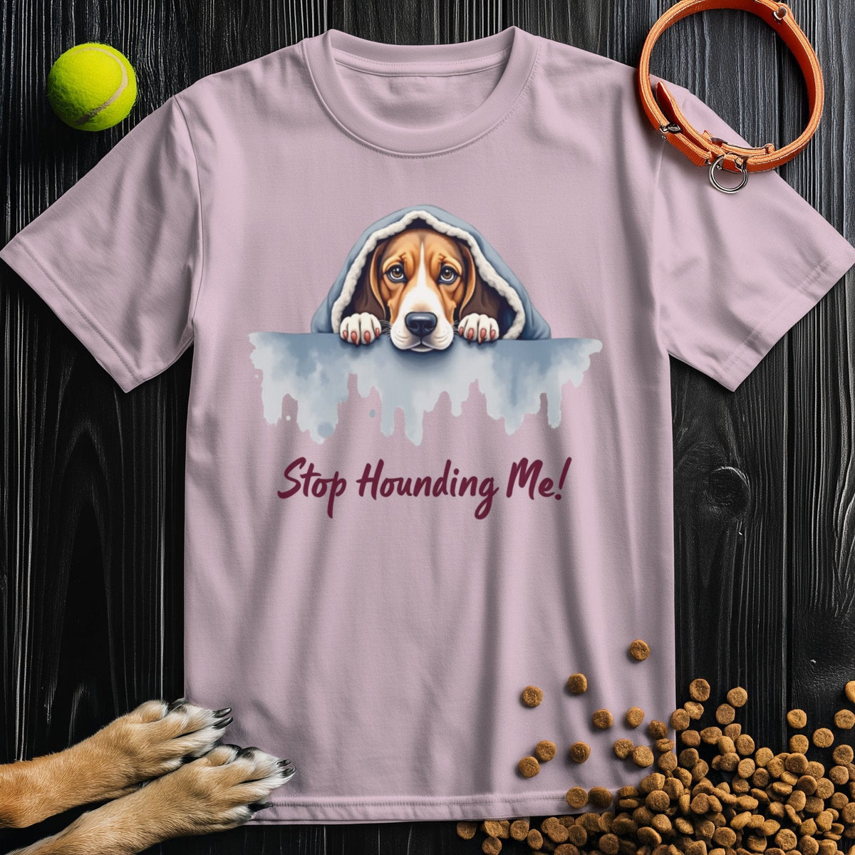 Light pink Stop Hounding Me T-Shirt with a watercolor hound dog design. Cozy cotton tee perfect for dog fans and summer wear.