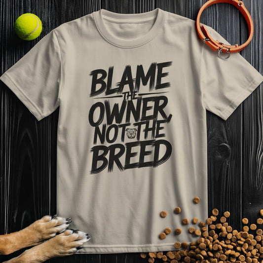 Beige dog lovers' t-shirt with bold 'Blame the Owner Not the Breed' slogan in black. Made from 100% cotton, ideal for pet advocates.
