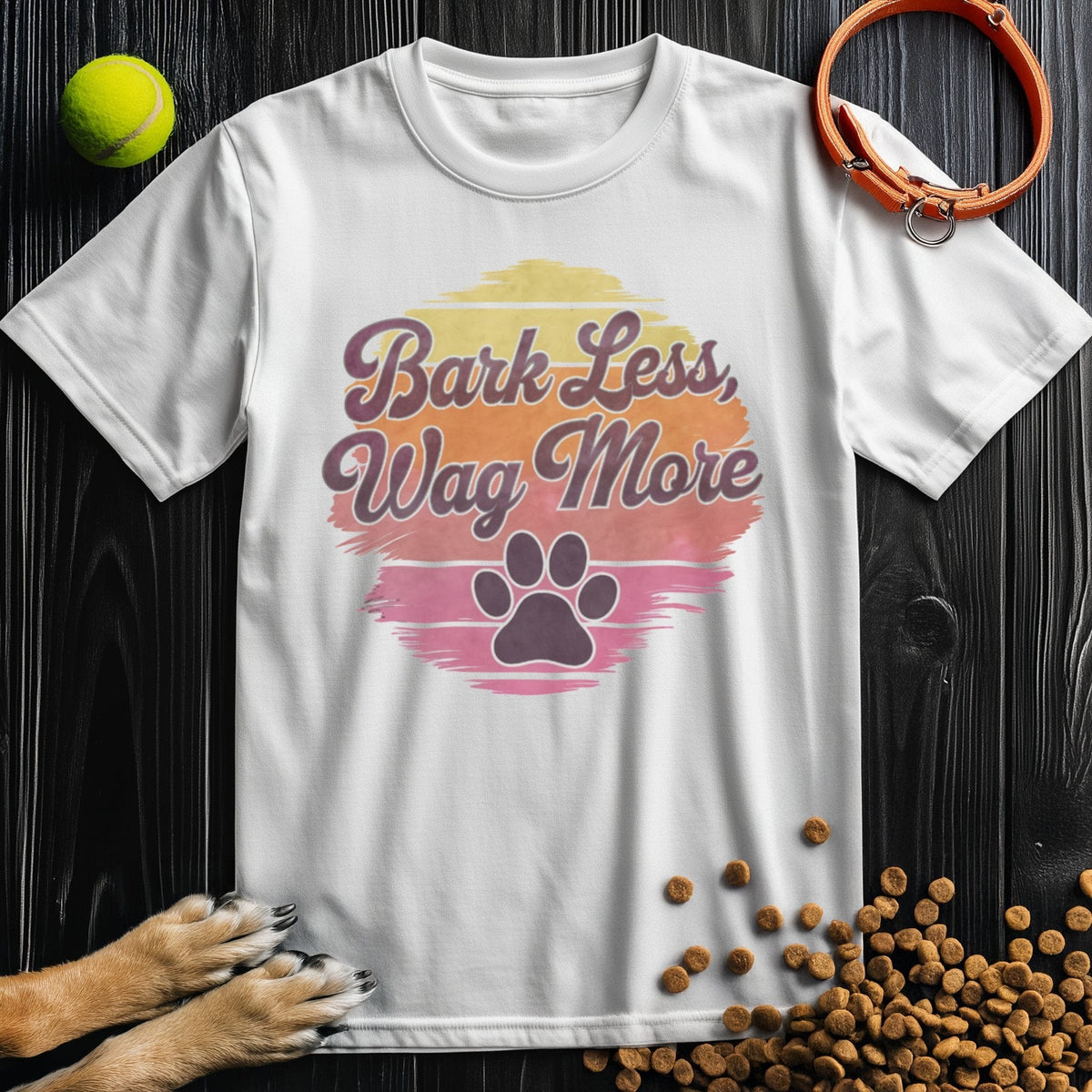 White Bark Less, Wag More T-Shirt with colorful paw print design. Unisex cotton shirt perfect for dog lovers and casual wear.