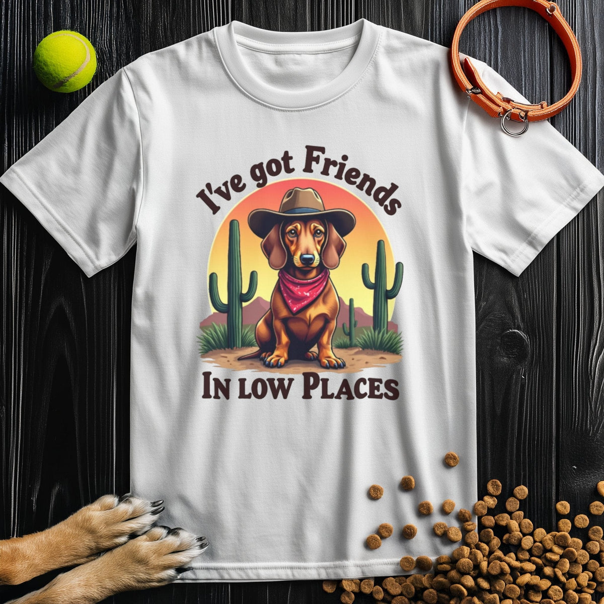 White 'I've Got Friends In Low Places T-Shirt' with a cowboy dog print, made from soft cotton and great for dog enthusiasts.