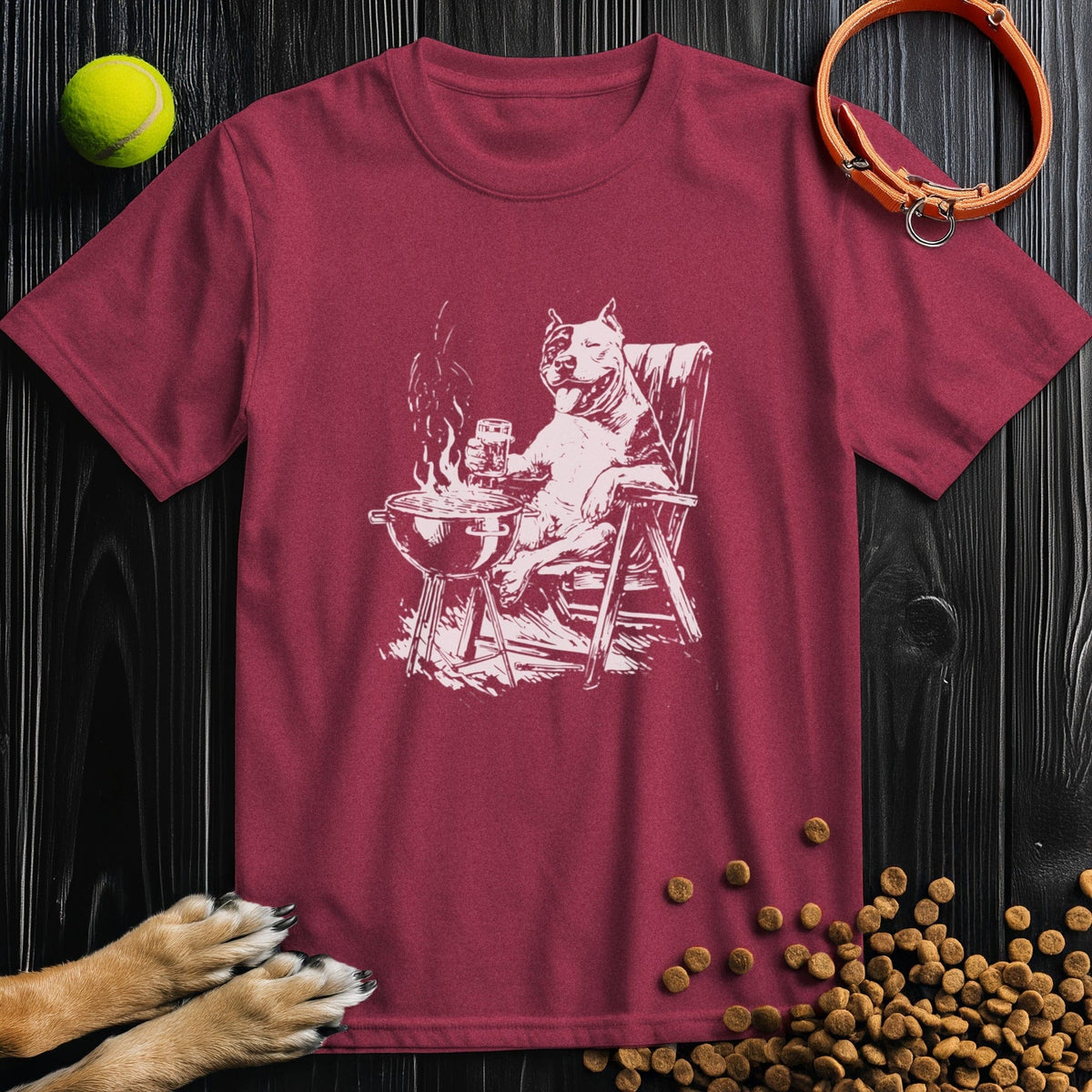 Dog mom and dad tee with relaxed roasting slogan in white on a heather cardinal tee of a pitbull cooking out

